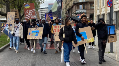Demogruppe läuft mit Plakaten auf der Straße