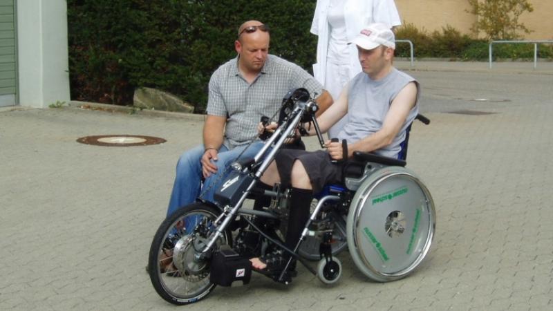 Stefan probiert mit seinem mechanischen Rollstuhl ein Handbike aus.