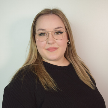 Portrait von blonder Frau mit Brille und schwarzem Shirt