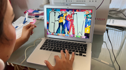 Eine Frau schaut in ihren geöffneten Laptop