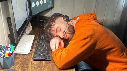 Protagonist schlafend am Arbeitsplatz 