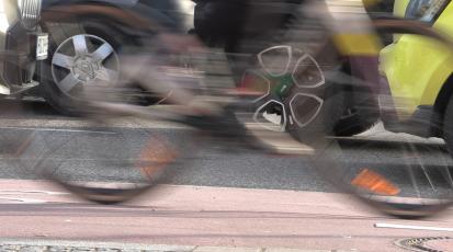 Fahrrad fährt vor Autos vorbei