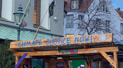 Schild mit Schriftzug "Climate Justice Now"