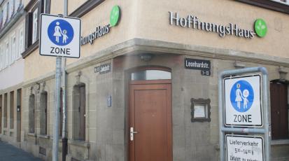 Hausecke, mit Tür in der Ecke. Fassade trägt auf beiden Seiten die Aufschrift Hoffnungshaus.
