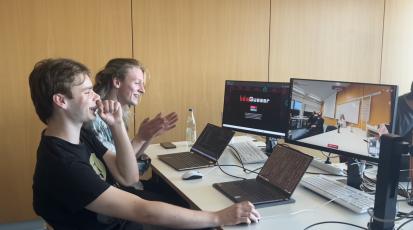 Zwei Projektmitglieder testen HdMGuessr an einem gemeinsamen Arbeitsplatz.