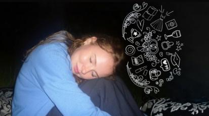 Frau sitzt im Dunkeln. Die beine sind an den Körper herangezogen und der Kopf ist auf den Knien abgelegt.