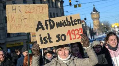  Demonstrierende Personen, die Schilder mit Anti-AfD-Sprüchen hochhalten. 