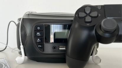 Ein CD Player mit einem Controller und Kopfhörer davor.