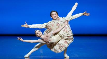 Ein Balletttänzer und eine Balletttänzerin führen bei einem Auftritt eine Hebefigur durch.
