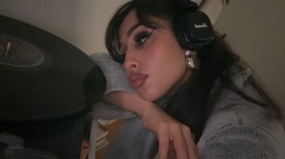 Junges Mädchen blickt melancholisch auf eine Schallplatte