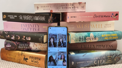 Bücherstapel mit einem Handy davor, auf dem Tiktok geöffnet ist