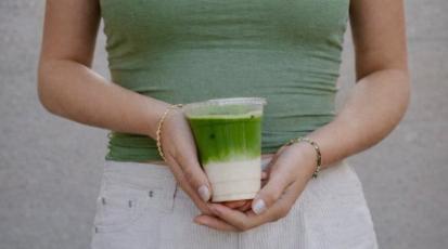 Bild einer Frau, die einen Matcha-Becher hält