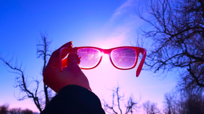 Pinke Brille vor einem rosa-blauen Himmel