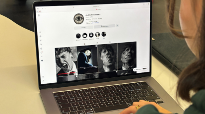 Zu sehen ist eine Frau von hinten, der Fokus liegt auf dem Laptop vor ihr. Auf dem Bildschirm ist der Instagram-Kanal "doublethinkdouble" zu sehen.