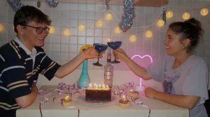 Zwei Freunde feiern Geburtstag mit Kuchen und Kerzen