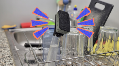 Eine Spülbürste steht in einem Abtropfbecken mit Abwasch. Rechts und links neben der Spülbürste sind gezeichnete Führungslinien.