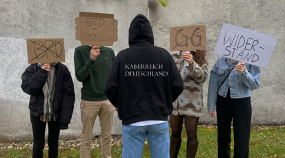 Symboldbild einer Reichsbürger-Demo mit Schildern.
