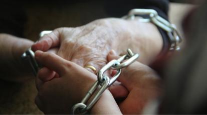 Die zusammengelegten Hände einer jungen und einer älteren Frau sind in Ketten gelegt