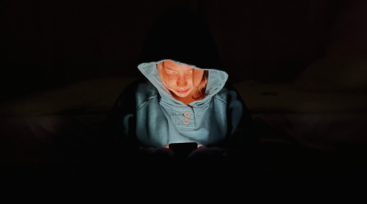 Dunkles Zimmer; ich habe mein Handy in der Hand und das Display erhellt mein Gesicht.