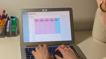 Person sitzt vor einem Kalender mit 4-Tage-Woche