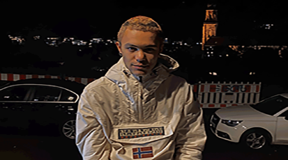 Foto von Protagonist*in Loerdy, in dem die Person ein weiße Jacke trägt und nachts im Dunkeln auf der Straße steht