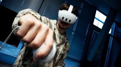 Ein Mann mit einem VR-Headset und Controllern ist zu sehen.