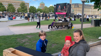Im Open-Air Kino auf dem Schlossplatz sehen drei Besucher eine Weltpremiere