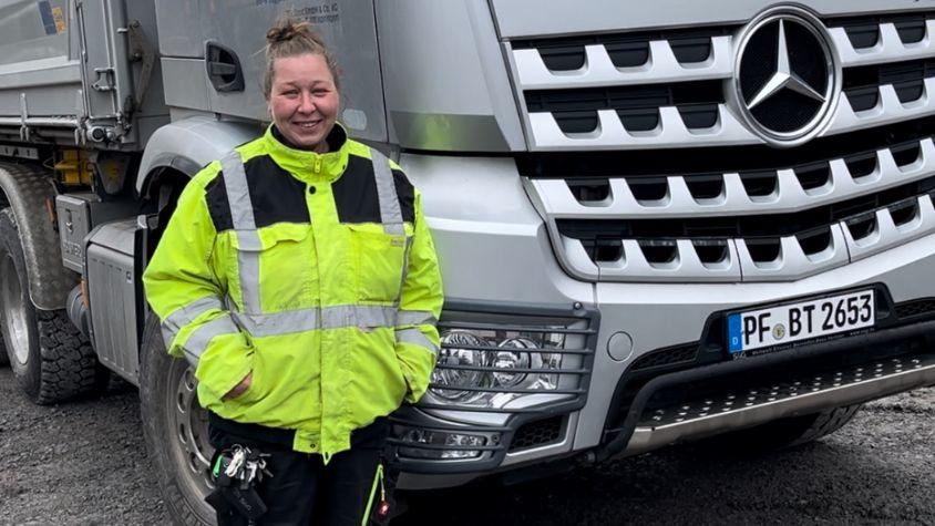 Frau, die vor LKW steht.