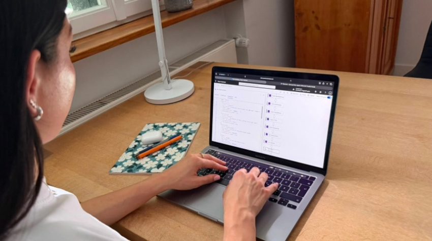 Lilly Steiner arbeitet am Schreibtisch auf ihrem Laptop an dem KI-Agent.