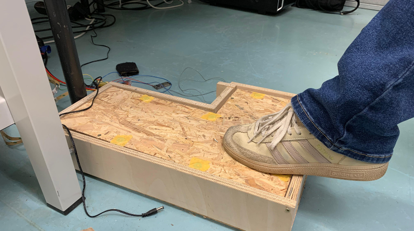 Ein Fuß betätigt den Prototypen einer Klaviertaste.