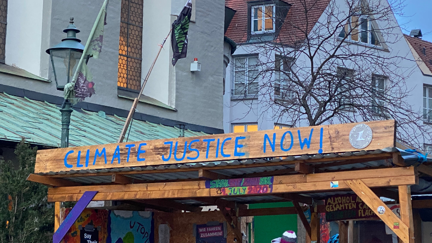 Schild mit Schriftzug "Climate Justice Now"