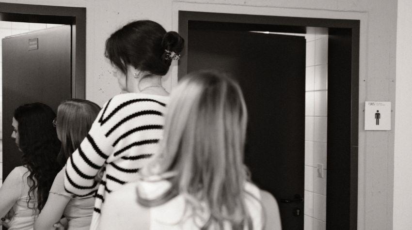 Eine Schlange vor der Frauentoilette. Die Männertoilette ist frei.