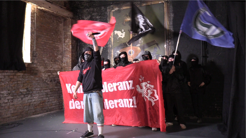 Rapper Flaiz und die Linksjugend, alle vermummt, Linke Flaggen zu sehen.