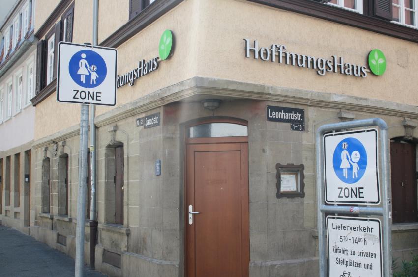 Hausecke, mit Tür in der Ecke. Fassade trägt auf beiden Seiten die Aufschrift HoffnungsHaus.