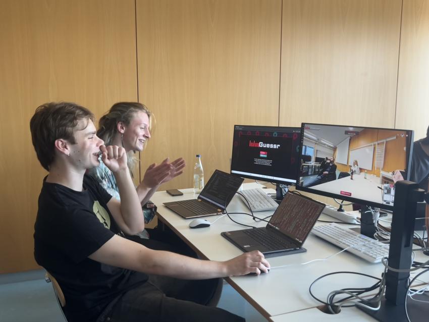 Zwei Projektmitglieder testen HdMGuessr an einem gemeinsamen Arbeitsplatz.