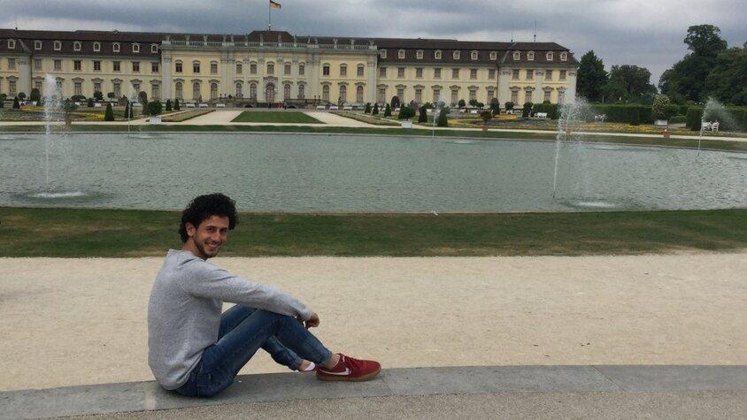 Josef sitzt vor dem Schloss in Ludwigsburg.