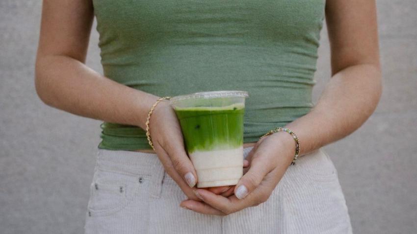 Bild einer Frau, die einen Matcha-Becher hält 