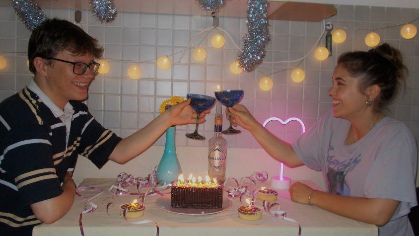 Zwei Freunde feiern Geburtstag mit Kuchen und Kerzen