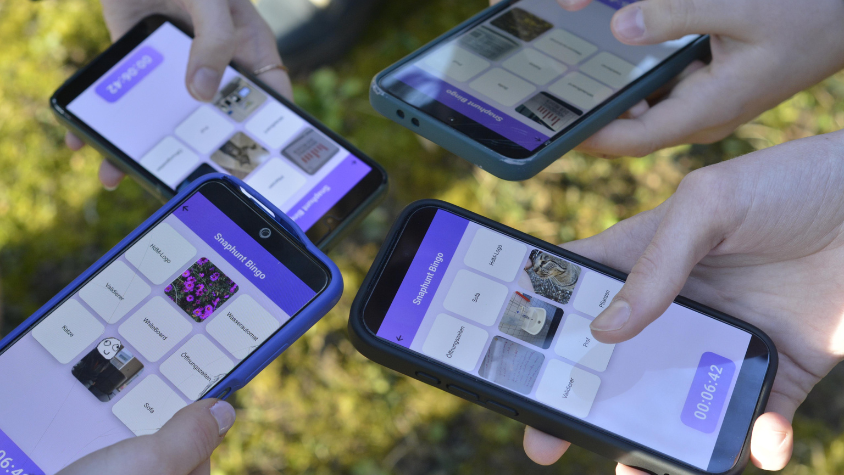 Mehrere Hände, die jeweils ein Handy halten, auf welchen der Prototyp der App zu sehen ist. 