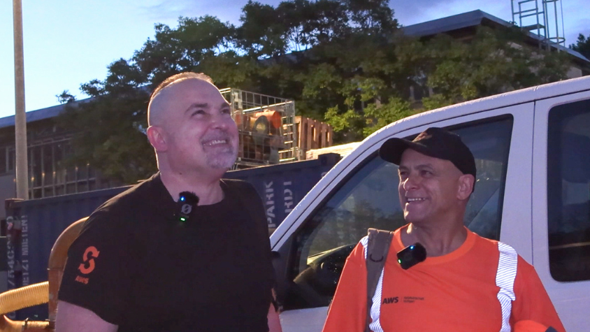 Jose und Pavlos vor einem Auto der Abfallwirtschaft Stuttgart