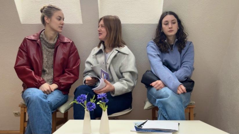 Drei Frauen im Wartezimmer. Zwei davon reden miteinander.