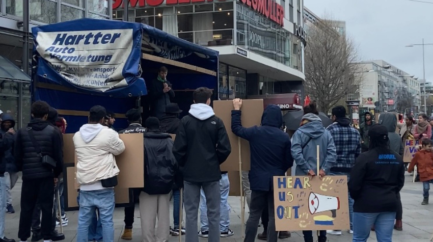 Demogruppe steht vor einer Bühne am Rotebühlplatz