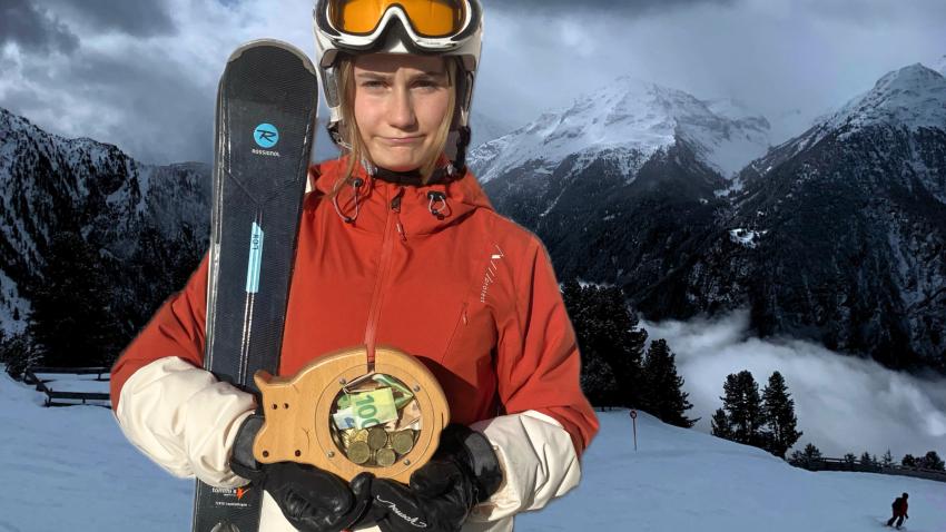 Skifahrerin mit Sparschwein in der Hand