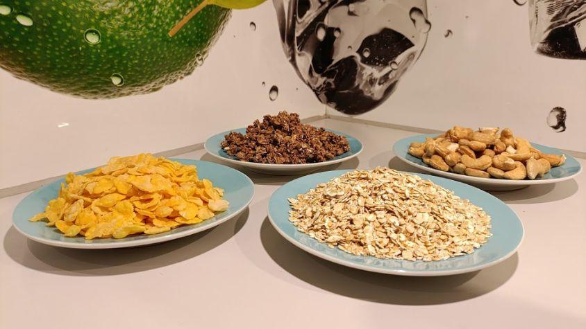 Zu sehen sind vier kleine Häufchen von unterschiedlichen Lebensmitteln wie Müsli, Haferflocken und Nüssen.