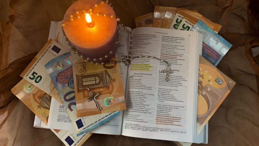 Eine Bibel mit Kreuzkette und Kerze