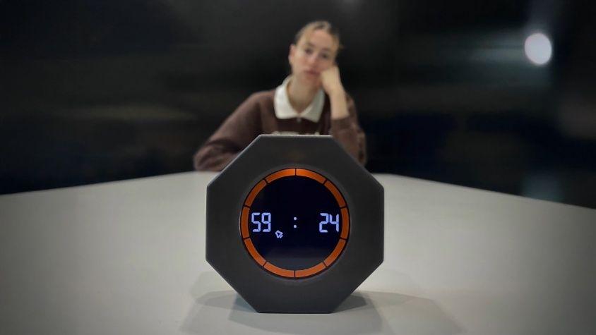 Person, die gelangweilt in einem monotonen Raum sitzt und auf einen Timer guckt