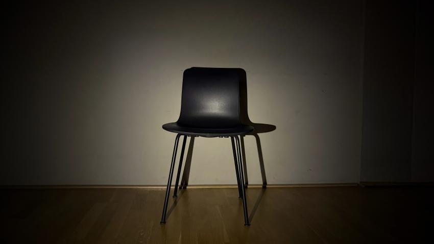 Leerer Stuhl wird von einem Lichtstrahl beleuchtet