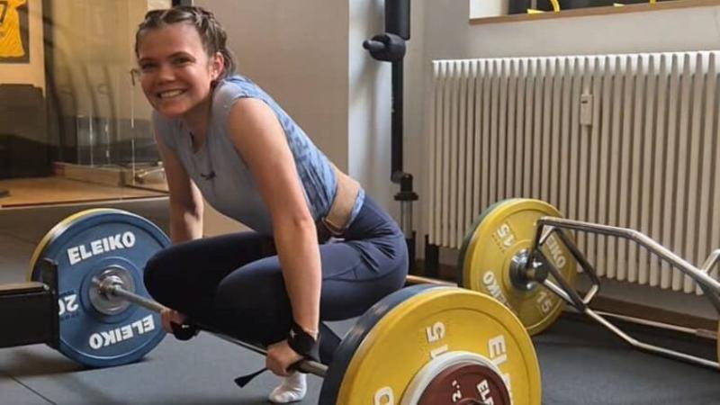 Agnes Reisch im Kraftraum, in der Hocke mit einer Langhantel.