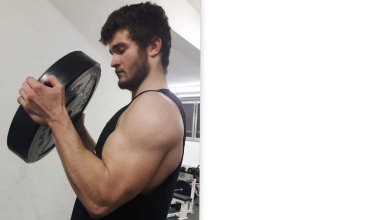 Marcel hebt im Fitnessstudio ein Gewicht.