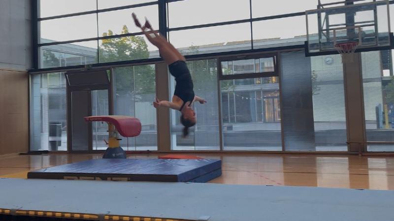 Helena turnt einen Strecksalto am Boden